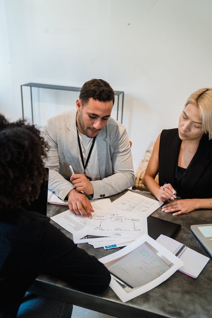 Diverse team engaged in collaboration, reviewing documents at an office desk.